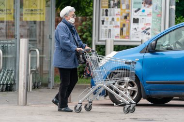 PECS - 27 Mayıs: 27 Mayıs 2020 tarihinde yaşlı kadın Pecs, Macaristan 'da alışverişe gider. Coronavirus salgını sırasında herkes maske takmak zorundadır.