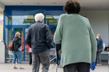 PECS - 27 Mayıs 2020 tarihinde Macaristan 'ın Pecs kentinde yaşlı insanlar alışverişe gider. Coronavirus salgını sırasında herkes maske takmak zorundadır.