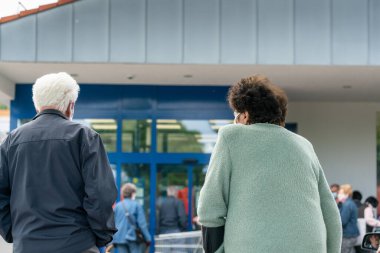 PECS - 27 Mayıs 2020 tarihinde Macaristan 'ın Pecs kentinde yaşlı insanlar alışverişe gider. Coronavirus salgını sırasında herkes maske takmak zorundadır.