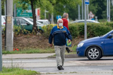 PECS - 27 Mayıs 2020 tarihinde Macaristan 'ın Pecs kentinde yaşlı insanlar alışverişe gider. Coronavirus salgını sırasında herkes maske takmak zorundadır.