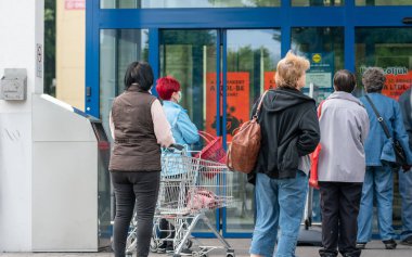 PECS - 27 Mayıs 2020 tarihinde Macaristan 'ın Pecs kentinde yaşlı insanlar alışverişe gider. Coronavirus salgını sırasında herkes maske takmak zorundadır.