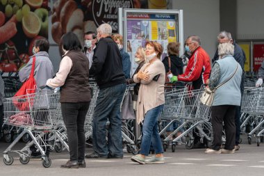 PECS - 27 Mayıs 2020 tarihinde Macaristan 'ın Pecs kentinde yaşlı insanlar alışverişe gider. Coronavirus salgını sırasında herkes maske takmak zorundadır.