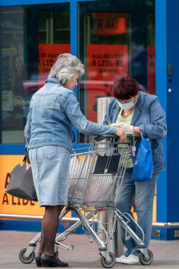 PECS - 27 Mayıs 2020 tarihinde Macaristan 'ın Pecs kentinde yaşlı insanlar alışverişe gider. Coronavirus salgını sırasında herkes maske takmak zorundadır.