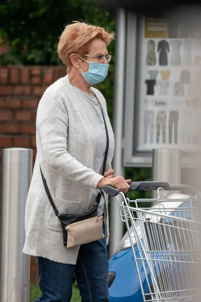 PECS - 27 Mayıs: 27 Mayıs 2020 tarihinde yaşlı kadın Pecs, Macaristan 'da alışverişe gider. Coronavirus salgını sırasında herkes maske takmak zorundadır.