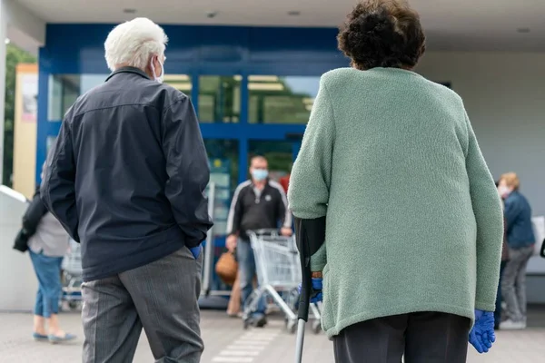PECS - 27 Mayıs 2020 tarihinde Macaristan 'ın Pecs kentinde yaşlı insanlar alışverişe gider. Coronavirus salgını sırasında herkes maske takmak zorundadır.