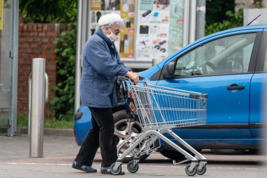 PECS - 27 Mayıs: 27 Mayıs 2020 tarihinde yaşlı kadın Pecs, Macaristan 'da alışverişe gider. Coronavirus salgını sırasında herkes maske takmak zorundadır.