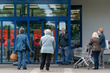 PECS - 27 Mayıs 2020 tarihinde Macaristan 'ın Pecs kentinde yaşlı insanlar alışverişe gider. Coronavirus salgını sırasında herkes maske takmak zorundadır.