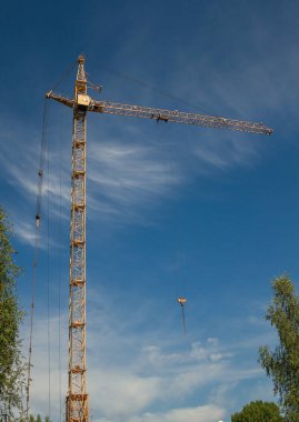 mavi gökyüzü arka plan beyaz bulutlar ve ağaçları ile vinç