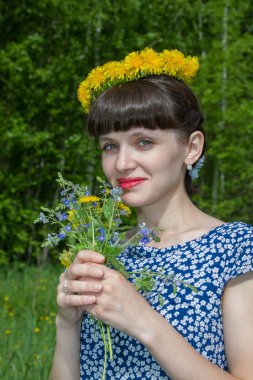 Dandelions çelenk ve kır çiçekleri buketi parkta güzel kız