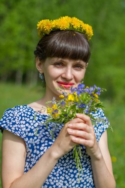 Dandelions çelenk ve kır çiçekleri buketi parkta güzel kız