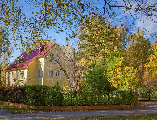 Arka plan mavi gökyüzünün ve parlak sonbahar ağaç ev.