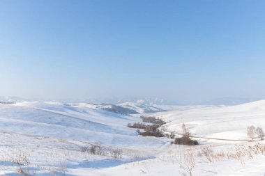 Güzel, kış dağ manzarası açık, mavi gökyüzü, ağaçlar ve Altay bölgesi yoldan gidiyor arka plan üzerinde