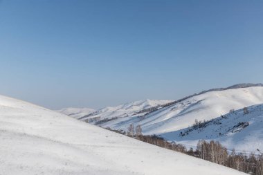 Güzel, kış dağ manzarası açık, mavi gökyüzü, ağaçlar ve Altay bölgesi yoldan gidiyor arka plan üzerinde