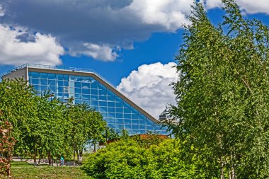 Bulutlar ve ağaçlar ile gökyüzüne karşı mavi Pencereler ile güzel bina