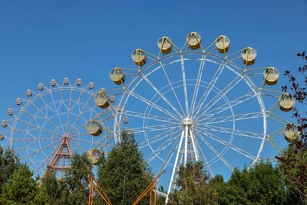 Mavi gökyüzünün arka planda Novosibirsk kentinde St Michael rıhtımında dönme dolap.