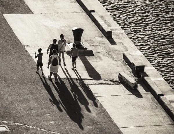 Silhouettes Groupe Personnes Projetant Longues Ombres Sur Une Route Asphaltée — Photo