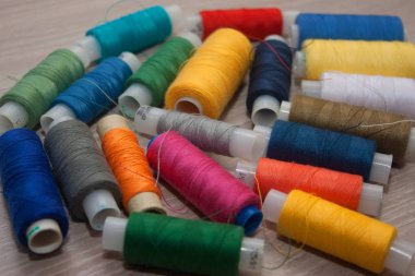 ahşap zemin üzerinde çok renkli dikiş ipliği