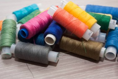 ahşap zemin üzerinde çok renkli dikiş ipliği