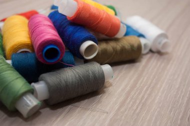 ahşap zemin üzerinde çok renkli dikiş ipliği