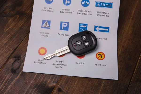 Kavram - öğretim sürüş. Yol işaretleri ve arabanın anahtarlarını closeup — Stok fotoğraf