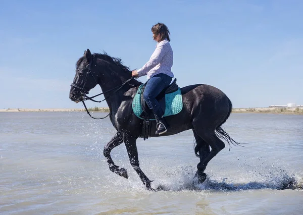 女人骑着她的种马在沙滩上 — 图库照片