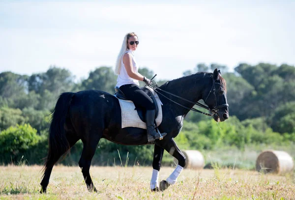 骑自行车的姑娘正在训练她的黑马 — 图库照片