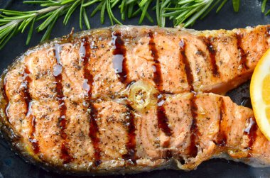 Siyah tabakta ızgara balık. Yakın plan.