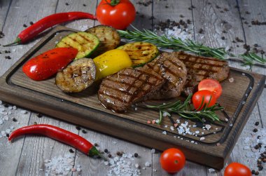 Tahta üzerinde sebzeli biftek yakın plan.