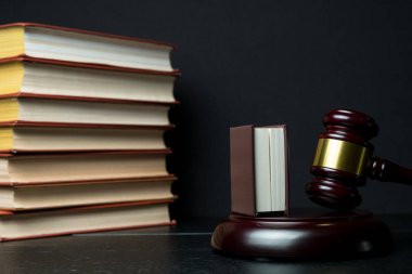 Yargıç tokmak yanında yığın kitap ahşap arka plan üzerinde