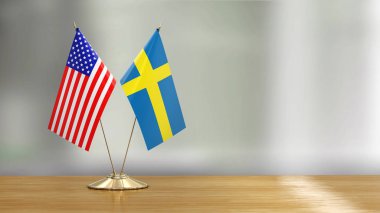 Defokus arka plan üzerinde bir masada Amerikan ve İsveç bayrak çifti 