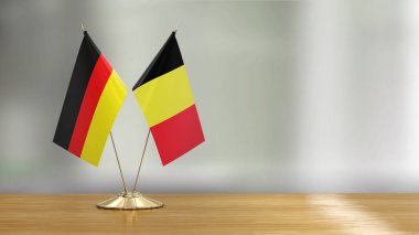 Belçikalı ve Alman bayrak çifti defokus arka plan üzerinde bir masada 