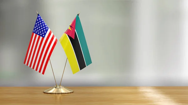 アメリカとモザンビークの旗のペアは デフォーカスの背景の上に机の上にペア — ストック写真