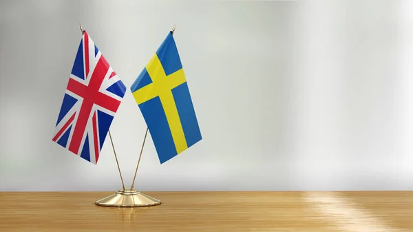 British and Swedish flag pair on a desk over defocused background
