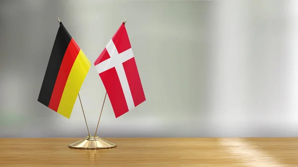 Dänische Und Deutsche Flagge Auf Einem Schreibtisch Vor Defokussiertem Hintergrund — Stockfoto