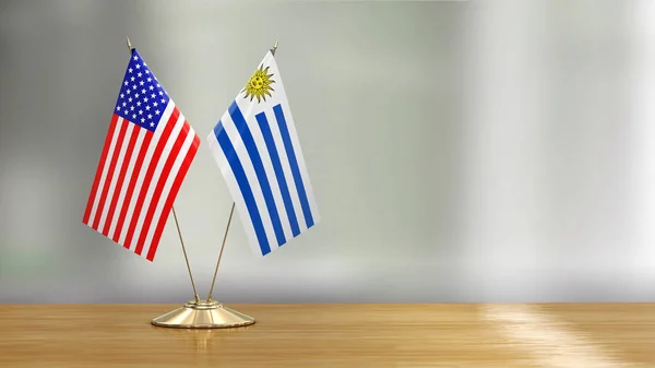 美国和乌拉圭国旗搭配在一张桌子上 背景分散了焦点 — 图库照片