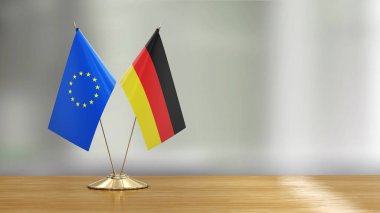 Avrupa Birliği ve Alman bayrak çifti dağılmış arka plan üzerinde bir masada 