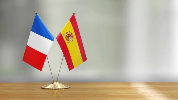 Französische Und Spanische Flagge Auf Einem Schreibtisch Vor Defokussiertem Hintergrund — Stockfoto