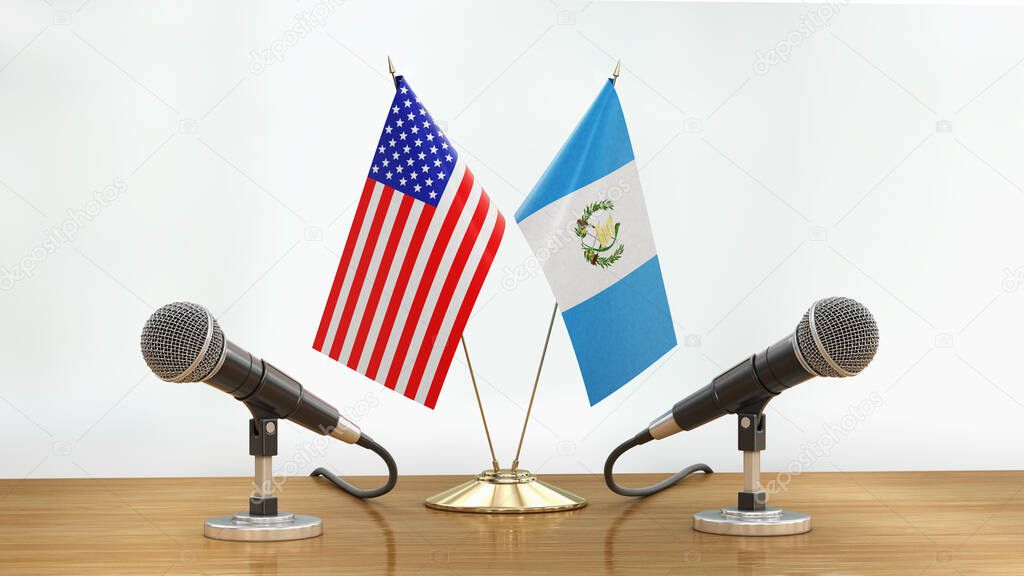 Microphones and flags pair on a desk over defocused background