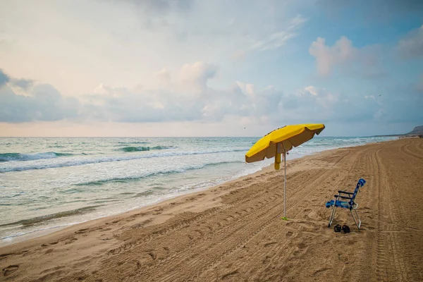 地中海のビーチに朝の早い時間で植えられた最初のサンシェード — ストック写真