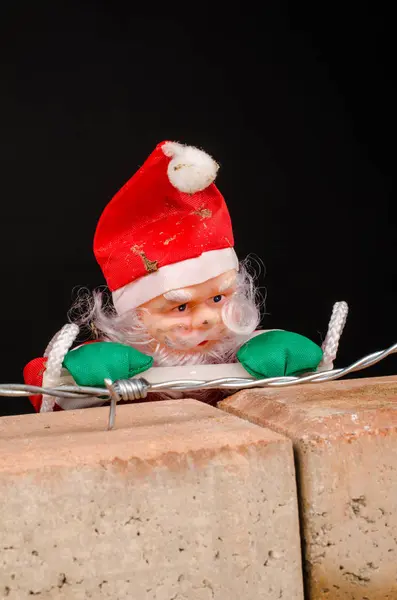 Santa Docka Försöker Klättra Väggen Invandring Koncept Mot Svart Bakgrund — Stockfoto