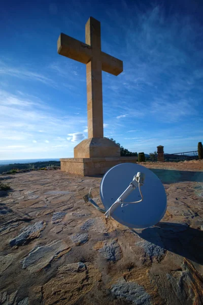 Christian cross monument and satellite dish