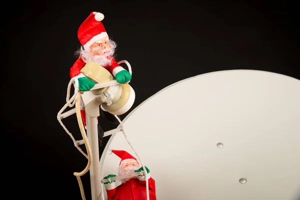圣诞老人爬上卫星天线 全球化的概念 — 图库照片