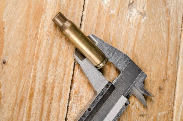 Bullet with caliper on wooden board
