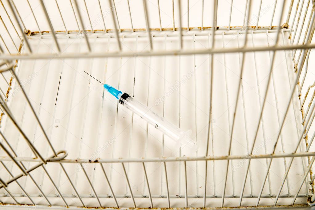 Syringe inside a cage, a conceptual shot on drug addiction and abuse