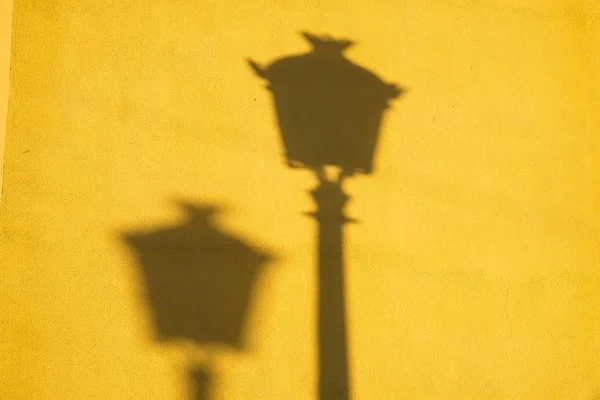 Long and strong winter light shadows on a yellow wall