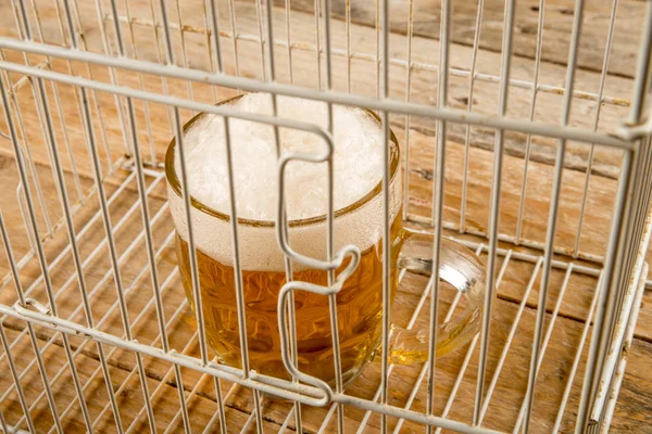Glass of beer in a cage — Stock Photo, Image