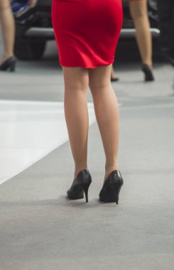 Kırmızı etekli ve çoraplı genç bir kızın güzel bacakları.