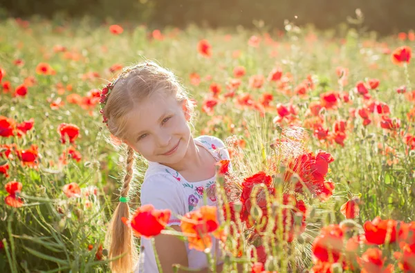 夕暮れ時のポピー フィールド間で花束を持つ少女 — ストック写真