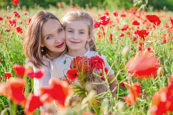 母亲黑发在白色礼服与女儿一起在绽放的红色罂粟地里 — 图库照片