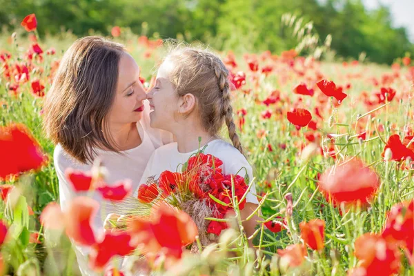 母亲黑发在白色礼服与女儿一起在绽放的红色罂粟地里 — 图库照片